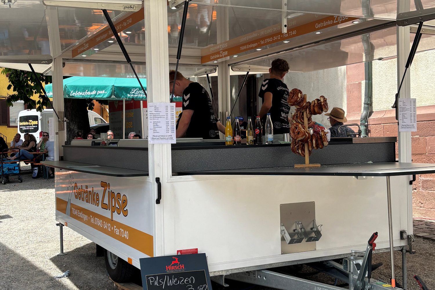 Ein Verkaufsstand mit Verkäufern und Spielzeugfiguren auf einem Markt.