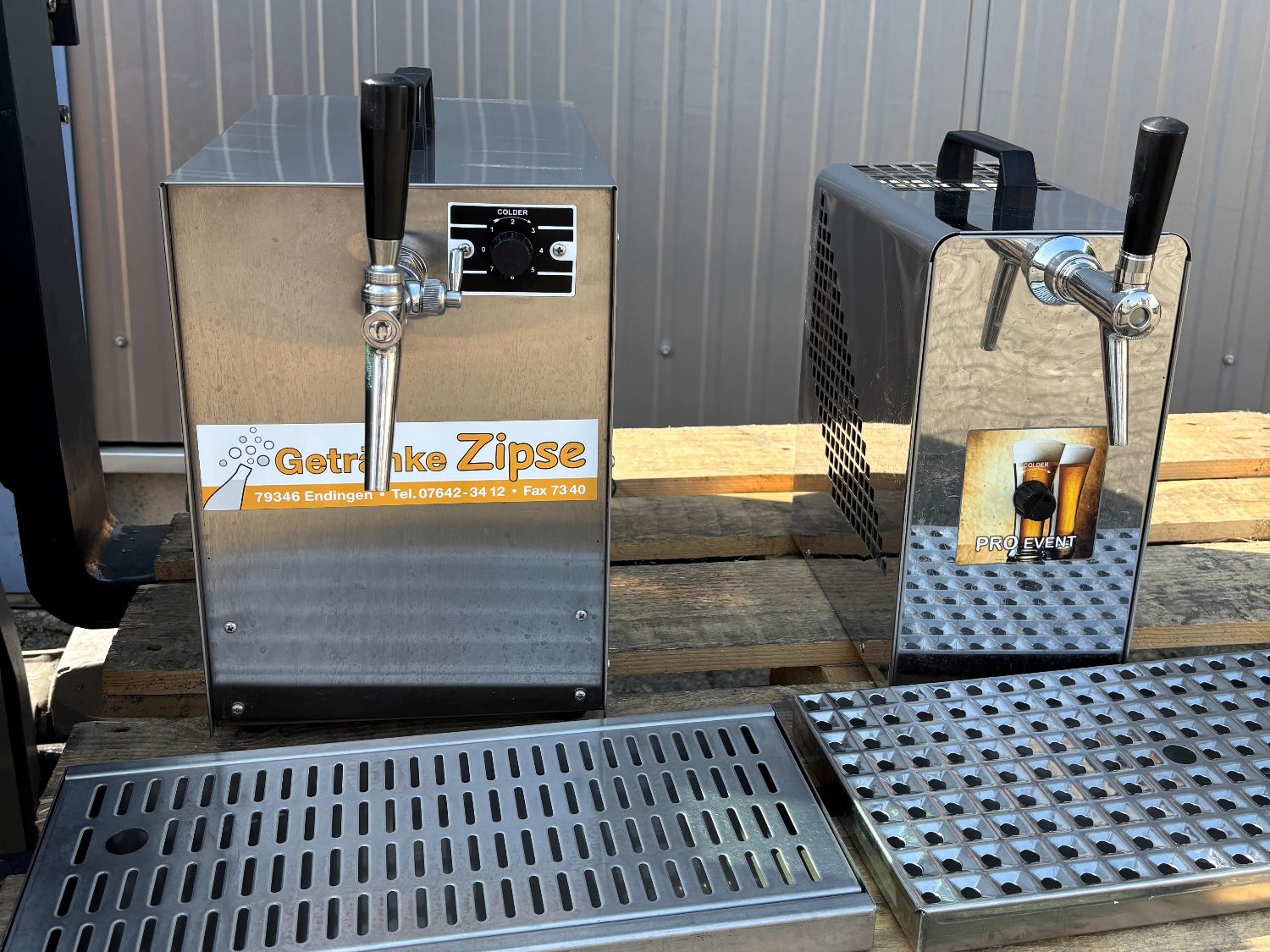 Durchlaufkühler / DLK Zwei Edelstahl-Durchlaufkühler mit Zapfhähnen auf einem Holztisch.