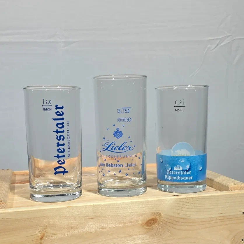 Drei verschiedene Gläser mit Beschriftungen auf einem Holzuntergrund.