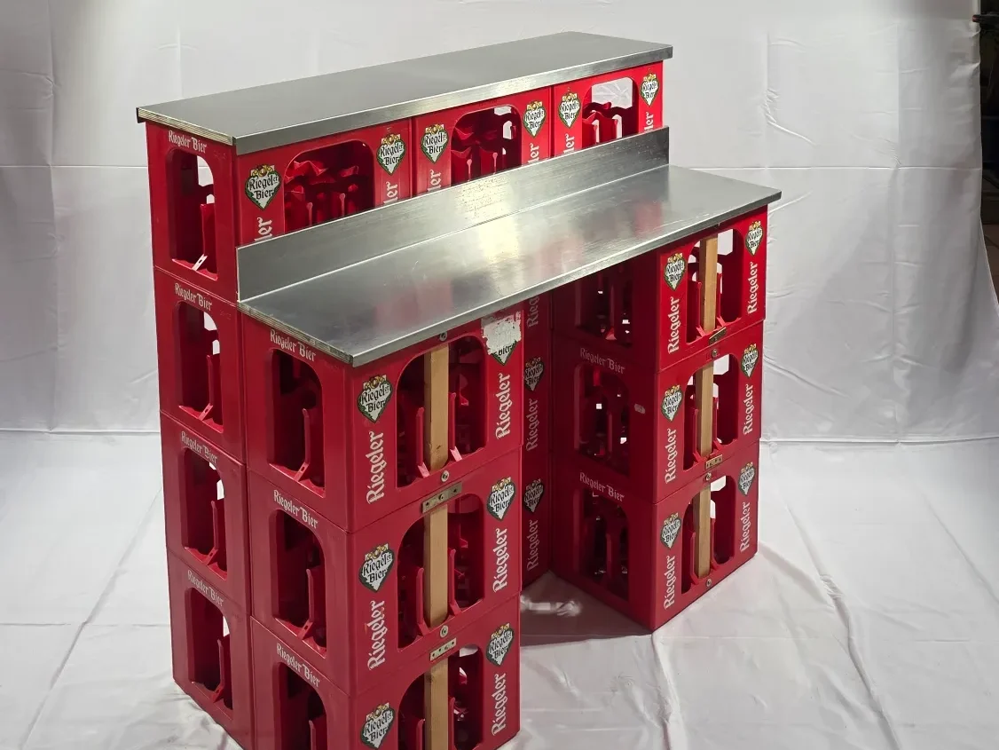 Bierkisten-Theken Rote Kisten mit Metalloberfläche, übereinander gestapelt, als Tisch verwendet.