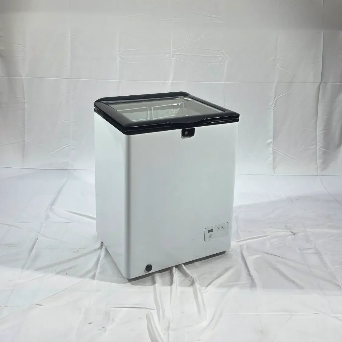 Kompakter, weiße Gefriertruhe mit schwarzem Deckel.