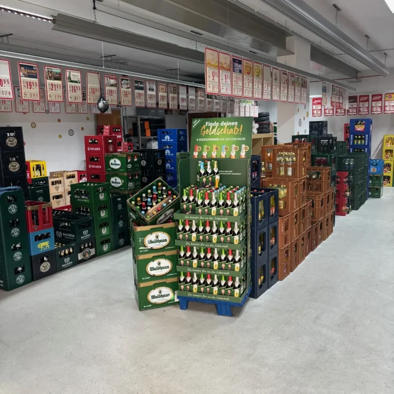 Bierkästen in verschiedenen Farben und Größen sind ordentlich gestapelt in einem Lagerraum.